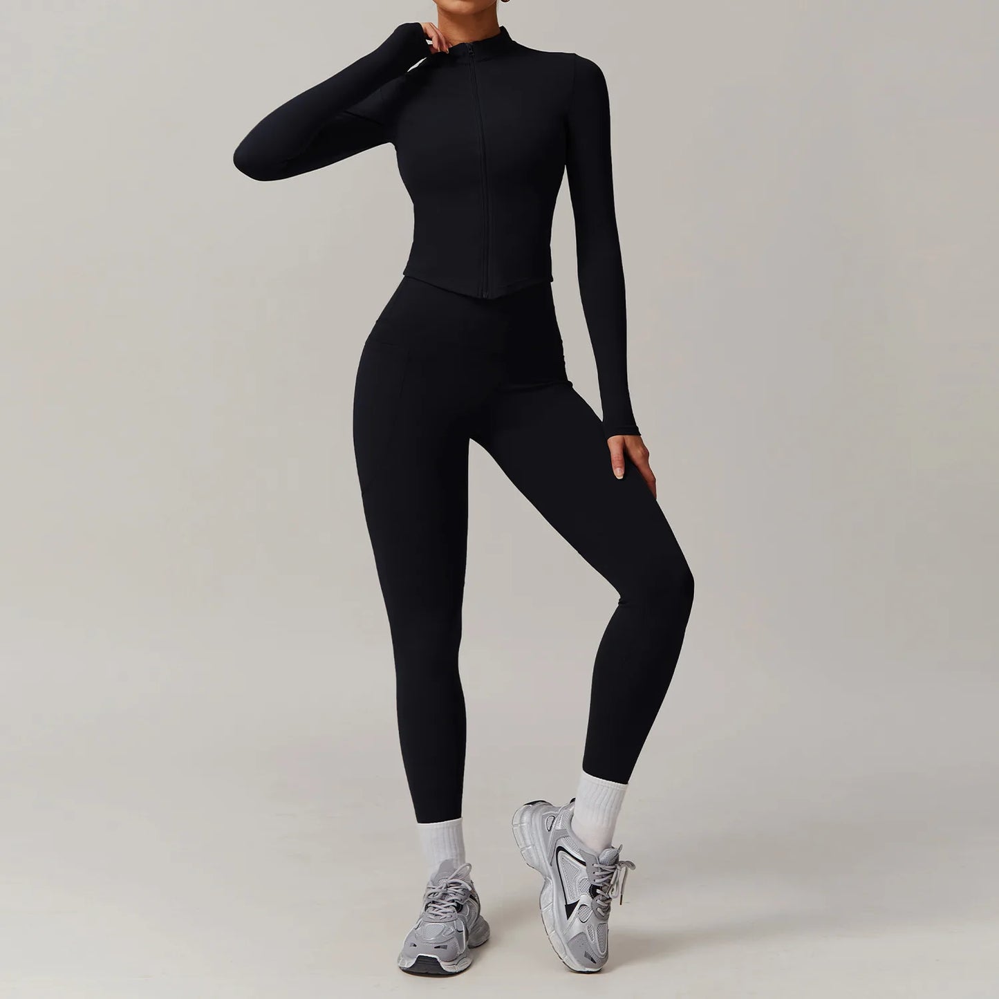 Black two-piece set with long-sleeve zip-up top and high-waisted leggings